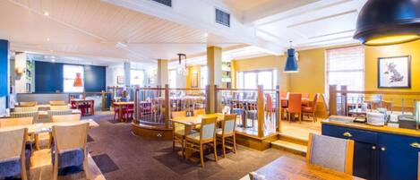 A spacious restaurant with high ceilings, multiple dining areas, and a variety of seating options.
