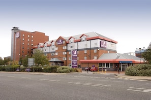 A hotel with multiple floors, a prominent Premier Inn sign, and a parking area in front. - Premier Inn Manchester Old Trafford (Manchester)