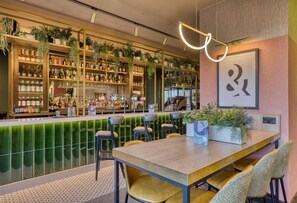 Eine Bar mit Regalen voller Flaschen, einer Theke und Sitzgelegenheiten.