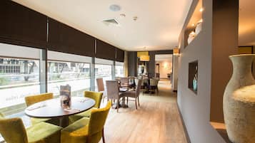 Una habitació d'hotel moderna amb zona de menjador, grans finestres i un gran vas.