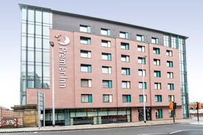 Un hôtel à plusieurs étages, reconnaissable à son grand panneau « Premier Inn », à ses larges fenêtres et à son architecture moderne.