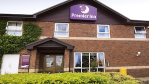 En byggnad av tegel med en lila skylt där det står ”Premier Inn” och ett litet markis över ingången.