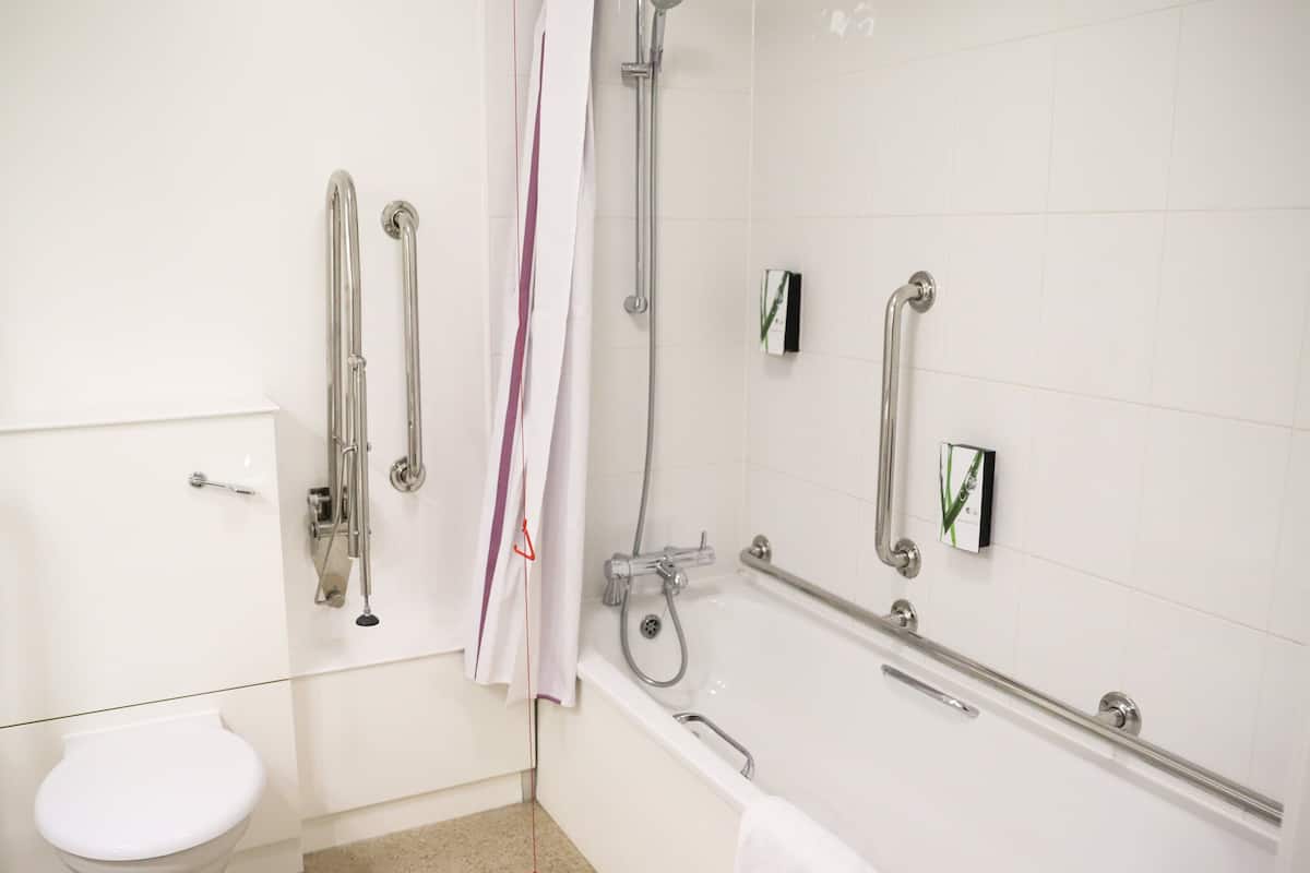 Habitación estándar con 2 camas individuales, bañera accesible | Baño accesible en silla de ruedas