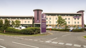 Een Premier Inn hotel met een bord waarop faciliteiten staan aangegeven, zoals een bar, restaurant, gratis verblijf voor kinderen en vergaderruimtes.
