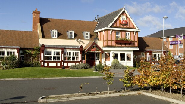 A traditional building with a prominent 'TOBY' sign, a brick chimney, and a well-maintained lawn. - Premier Inn Newcastle - Washington (Washington)