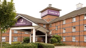 A hotel with a prominent 'Premier Inn' sign, a brick facade, and a covered entrance area. - Premier Inn Derby East (Derby)