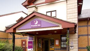 A hotel entrance with a marquee sign, a brick facade, and a tiled walkway. - Premier Inn Leicester - Braunstone (Leicester)