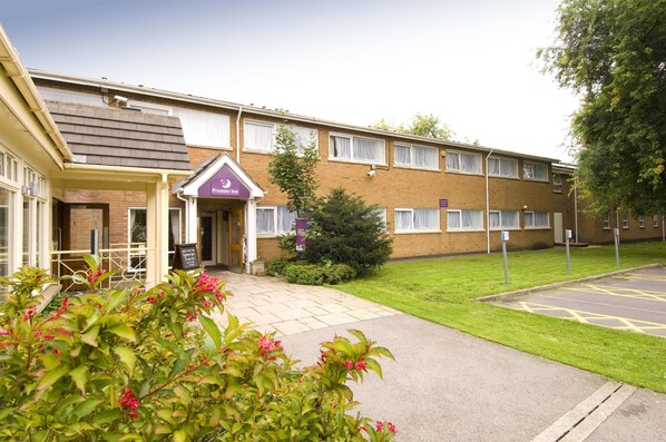 A building with a flat roof, a brick facade, and a sign indicating it is a Premier Inn. - Premier Inn Leicester - Forest East (Leicester)
