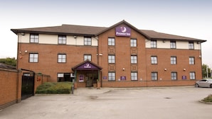 A two-story brick building with a sign for Premier Inn, a parking lot, and a car parked in front. - Premier Inn Nottingham Castle Marina (Nottingham)