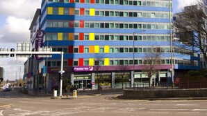 Ett hotell med flera våningar och modern design, med en tydlig logotyp på bottenvåningen.