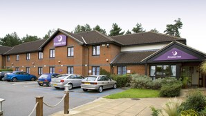 A Premier Inn hotel with a brick facade, multiple parking spaces, and a well-maintained garden area. - Premier Inn Norwich West - Showground/A47 (Norwich)