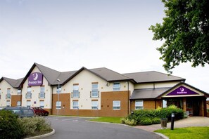 Ein Premier Inn Hotel mit Ziegelhausfassade, zahlreichen Fenstern und einem Parkplatz.