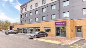 Un hôtel Premier Inn doté d’une façade moderne, de nombreuses fenêtres et d’un parking où sont garées des voitures.