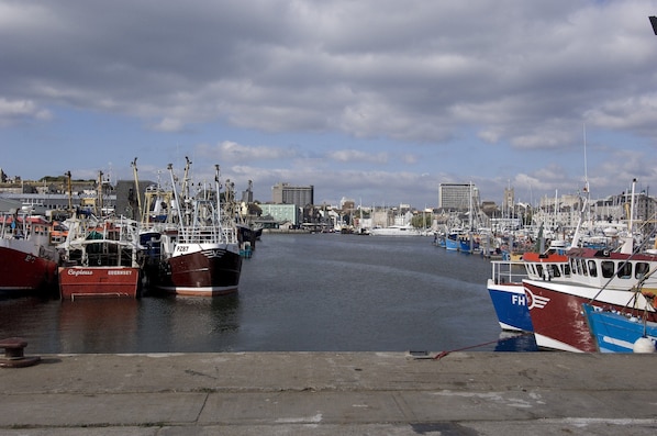 A marina with various boats docked, a clear sky, and buildings in the background. - Premier Inn Plymouth - Sutton Harbour (Plymouth)