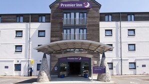Ein Hotel mit einem Schild, auf dem 'Premier Inn' steht, und einem überdachten Eingang.