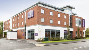 A modern hotel with a prominent Premier Inn sign, large windows, and a brick facade. - Premier Inn Fleet (Fleet)