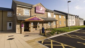 A hotel with a stone facade, a reception area, and a parking lot. - Premier Inn Helston (Helston)