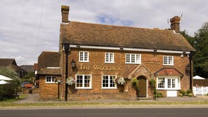 Un edificio tradizionale in mattoni con un cartello che riporta 'The Woolpack Restaurant & Pub'.