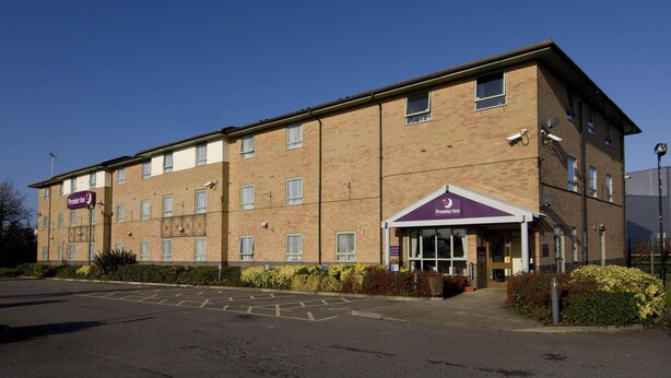 A two-story brick building with a flat roof, a visible entrance with a canopy, and a parking lot in front. - Premier Inn Ashford Central (Ashford)