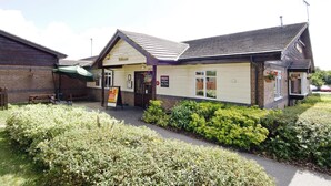 A two-story building with a sign reading 'Welcome' and a green umbrella. - Premier Inn Sittingbourne Kent (Sittingbourne)