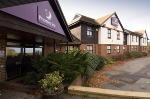 Un hotel Premier Inn con facciata in mattoni, ampie finestre e un’area di parcheggio.