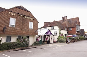 Un edificio tradicional con un cartel que dice 'THE WATERINGBURY' y otro cartel que indica 'FRONTIER INN'.