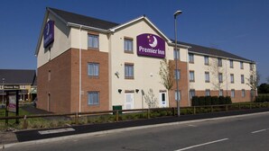 Ein Premier Inn Hotel mit Backsteinfassade, zahlreichen Fenstern und blauem Himmel.