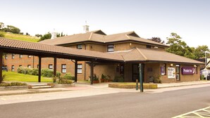 A brick building with a tiled roof, a covered entrance area, and a sign for Premier Inn. - Premier Inn Dover - A20 (Dover)