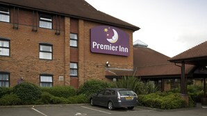 Ein Gebäude aus Backsteinen mit einem Schild für Premier Inn.