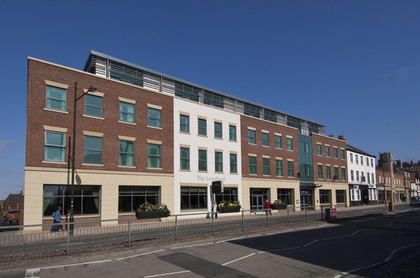 A multi-story building with a flat facade, large windows, and a sign reading 'The Longboat.' - Premier Inn York City - Blossom St South (York)