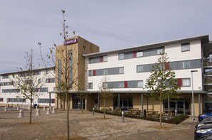 A hotel with a flat facade, multiple windows, and outdoor seating areas. - Premier Inn Rochester (Rochester)