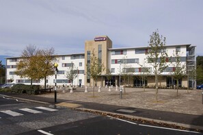 A hotel with a prominent 'Premier Inn' sign, a paved pedestrian area, and a crosswalk. - Premier Inn Rochester (Rochester)