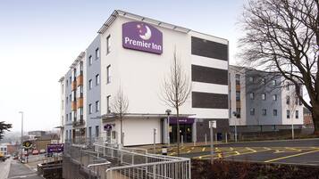 A Premier Inn hotel with a modern design, a visible entrance, and a parking area.