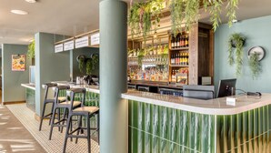 Un espace bar avec un comptoir, des tabourets et des étagères remplies de bouteilles.