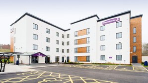 A Premier Inn hotel with a modern design, featuring a flat roof, multiple windows, and a parking area with marked spaces. - Premier Inn Stourbridge Town Centre (Stourbridge)