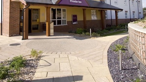 A Premier Inn hotel with a yellow facade, multiple windows, and a sign indicating the hotel name. - Premier Inn Llanelli Central East (Llanelli)