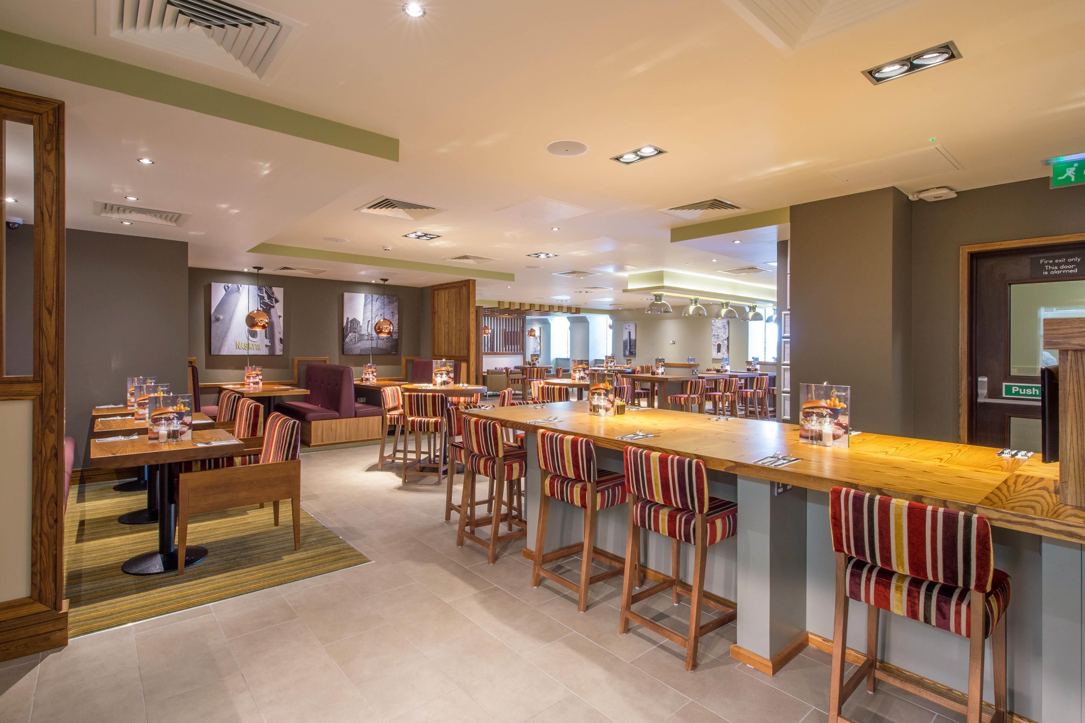 A spacious restaurant with multiple dining areas, a central bar, and a variety of seating options.
