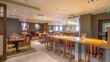 A spacious restaurant with multiple dining areas, a central bar, and a variety of seating options.