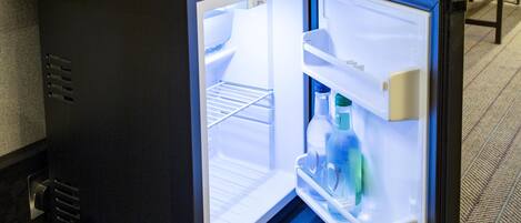 A compact refrigerator with a freezer compartment, a water dispenser, and a shelf.