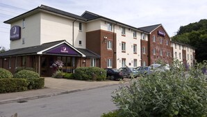 A hotel with a brick facade, a marquee sign, and a parking lot with cars. - Premier Inn Newport Wales - M4 J24 (Newport)
