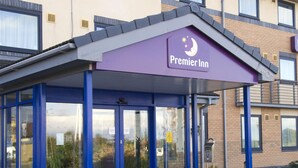 A Premier Inn hotel with a covered entrance, glass doors, and a clear view of the building's exterior.