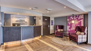A reception area with a desk, chairs, a patterned rug, and a wall with motivational quotes. - Premier Inn Basingstoke West (Basingstoke)