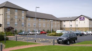 A hotel with multiple parking spaces, a pedestrian pathway, and a landscaped area. - Premier Inn Lancaster (Lancaster)