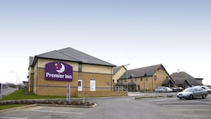 A Premier Inn hotel with a parking lot and a building with a sign. - Premier Inn St. Neots - Colmworth Park (St Neots)