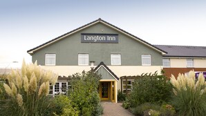 En bygning med et skilt, der viser 'Langton Inn', og en sti, der fører til indgangen.