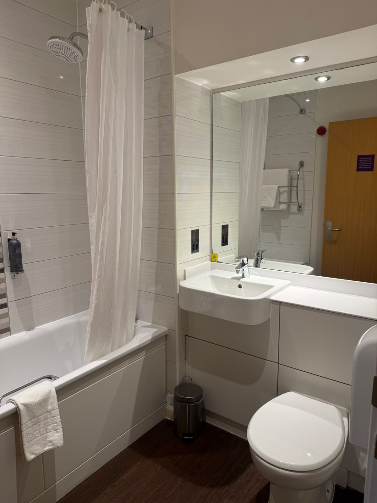 Un baño moderno con bañera, ducha, lavamanos e inodoro.
