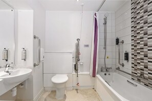 A modern bathroom with a white sink, toilet, and bathtub. - The Langton Inn (Market Harborough)