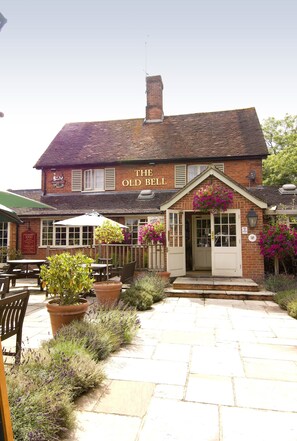 Step into THE OLD BELL, a charming traditional building with a cozy porch and inviting patio area.
