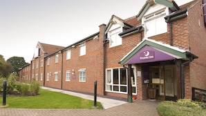 A brick building with a purple awning labeled 'Premier Inn.' - Premier Inn Runcorn (Runcorn)