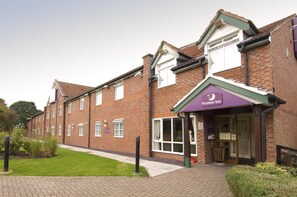 A brick building with a purple awning labeled 'Premier Inn.' - Premier Inn Runcorn (Runcorn)